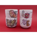 Two vintage stacked ceramic cups with retro butterfly and flower pattern 1970s