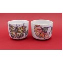 Two vintage stacked ceramic cups with retro butterfly and flower pattern 1970s