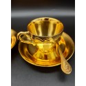 A pair of gold-plated coffee cups with spoons